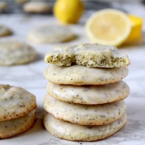 Glazed lemon poppy seed cookies stacked on top of each other