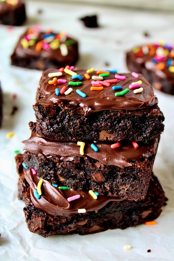 Chewy brownies with chocolate ganache on parchment paper