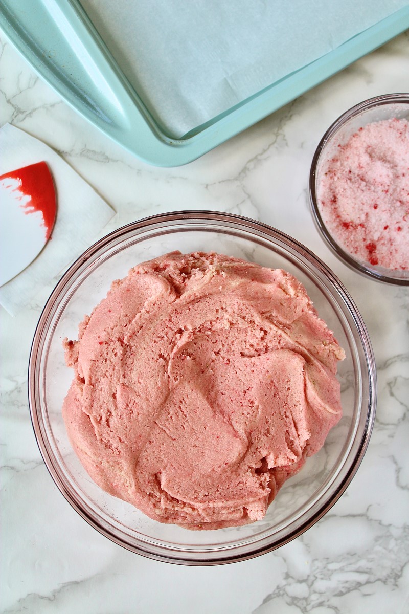 Strawberry sugar cookie dough in bowl with spatula on the side